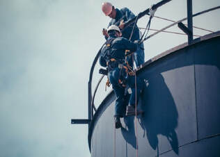 Two painters working at dangerous heights